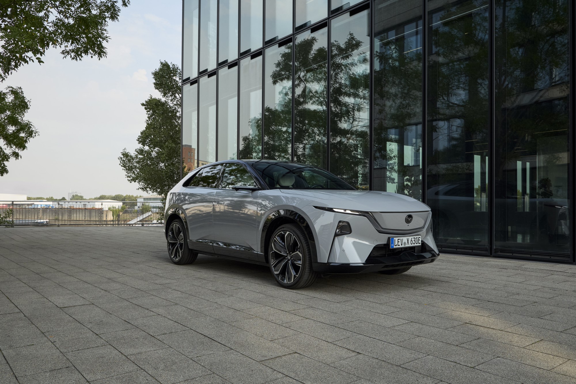 Mazda CX-6e elétrico branco estacionado junto a um edifício